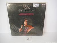Front cover of the Elvis Presley "He Touched Me" vinyl record album in protective plastic sleeve showing price tags and original artwork.
