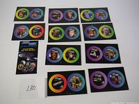Overall view of 14 Star Trek pogs with colorful rims arranged in rows on black backing cards, plus promotional insert card.