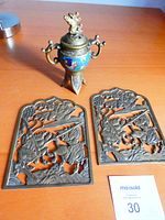 Full view of cloisonné incense burner with two brass cutaway panels on wooden surface.