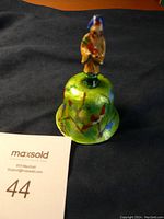 Photo of the green enamel Chinese bell with deity figurine on handle showing front and top detail