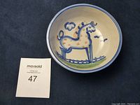 Top view of the child's pottery bowl showing handpainted pony inside with blue rim and green grass.