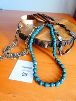 Full view of all necklaces and bangles displayed on wooden stand and table.