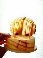 Onyx trinket box held open showing inner surface and metal hinges on the scalloped lid