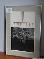 Framed print showing leaf design and garden rake artwork, with framed and matted borders.
