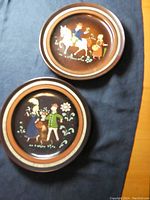 Two pottery plates with folk art courting couple paintings, viewed from front.