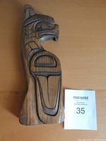 Front view of wooden Thunderbird wall hanging carved in Indigenous style by Charles Harper, showing full body and shape.