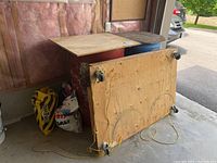 Wide angle view showing two large drums, wooden dolly resting upside down on top, and salt bags on the floor.