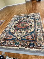 Full view of rug laid flat on floor showing overall pattern and condition