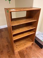Front angle of pine shelving unit showing the shelves and wood grain.