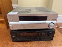 Top view showing Pioneer SX-315 receiver on top of Sony STR-AV970 receiver on hardwood floor.