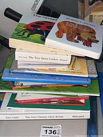 Stack of 12 colorful hardcover children's books, some board books, showing titles and authors including Eric Carle and others.
