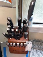 Photo showing the full knife set placed in a wooden block with Calphalon branding, including multiple knives and kitchen scissors.