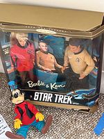 Full view of the Star Trek Barbie and Ken gift set in damaged packaging with the Disney Goofy doll in front.