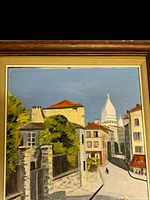 Full view of framed oil painting showing buildings, greenery, and a domed church in the background under a blue sky.