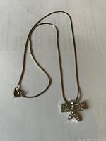 Overall view of vintage silver necklace with bow pendant and clear stones on a chain with spring clasp.