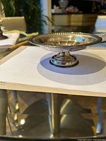 Side-angle view of round sterling silver pedestal bowl showing beaded rim and fluted interior