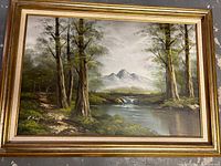 Front view of oil painting showing trees, river, waterfall, and mountains, signed R. Kay, in gold frame.
