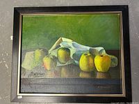 Front view of the framed oil on board painting showing five green apples with draped cloth and green background.