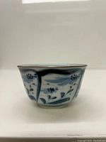 Side view showing hand painted blue floral and leaf panel designs with brown rim