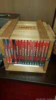 Front view showing 14 individual Sharpe's DVDs in a wooden crate case with visible titles on the DVD spines