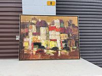 Full front view of the framed abstract painting on white table with storage unit background.