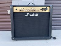 Front view of Marshall MG30FX guitar amplifier showing black casing, gold control panel with knobs, input jack, and the Marshall logo on the mesh grille.