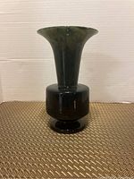 Front view of a spinach jade vase showing its flared rim and cylindrical body with pedestal base.