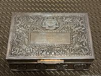 Top view of lid showing repousse design, Singapore coat of arms and engraved plaque