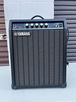 Front view of the Yamaha F-20B amplifier showing control panel and Yamaha logo on speaker grille.