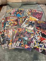 Photo of the entire comic book collection laid out on a surface, showing various X-Men and Wolverine issues.