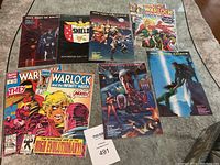 Nine Marvel comics laid out showing covers of S.H.I.E.L.D., Warlock and the Infinity Watch, and other titles.