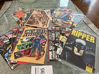 Overview of the comic book collection spread on a glass table, showing multiple titles including Captain America and Ripper.