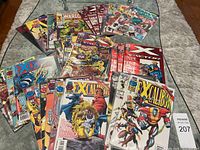 Overview of the comic books laid out on a rug showing multiple titles focusing on X-Men related series including Excalibur and Warlock.