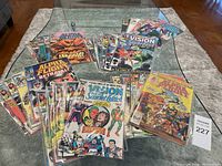 Full view of 31 Marvel comics spread and stacked on table showing covers of Alpha Flight, Vision and Scarlet Witch, and Hulk.