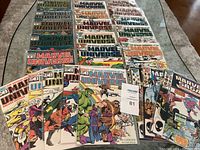 Full layout of 23 Marvel comic books and handbooks arranged on a table displaying all covers.