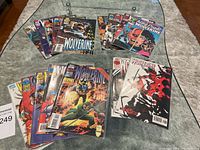 Collection of Wolverine Marvel comic books arranged on a glass table, displaying colorful covers and various issues.