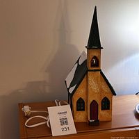 Side view of Department 56 light-up church showing plugged power cord and overall size approx 15 inches tall