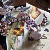 Lot displayed on table showing three ceramic bunny figurines and two Easter garden banners, featuring chicks and flowers