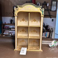 Front view of the Florentine decorative wooden display case showing six compartments and gold motifs.