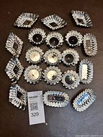 Top-down photo showing all 19 fluted tin tart molds arranged on a flat surface, displaying variety of shapes.