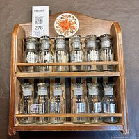 Full view of wooden spice rack with 12 glass bottles showing.
