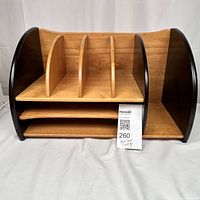 Front view showing three vertical dividers creating four slots, two horizontal shelves below, and one open compartment on right with rounded dark side panels.