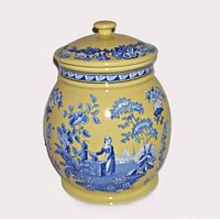 Full view of Spode canister jar with lid on, showing blue floral and woman at well scene on yellow background.