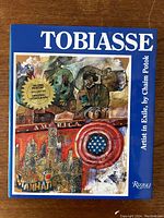 Blue cover of the art book with title 'Tobiasse' and a colorful illustration with a 'second printing includes original lithograph' seal.
