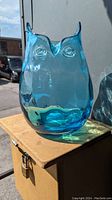 Front view of blue horned owl art glass vase showing facial features and overall shape.