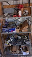 Four shelves of assorted car parts including boxed filters, gasket sets, hoses, and brake components.