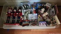 Overview of all Christmas decorations including nutcrackers, trains, nativity set figurines, angels, lamp toppers, and the storage bin.