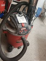 Red Craftsman 20 gallon wet/dry vacuum showing hose and power switch on top with 6.5 peak HP and 175 MPH blowing speed label.