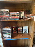 Shelves with multiple stacks of DVDs including Scarface, The Devil's Advocate, Smokey and the Bandit, Cool Hand Luke and more.