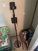 Full view of the Bounty Hunter Tracker IV metal detector standing vertically showing the search coil, shaft, and control box.